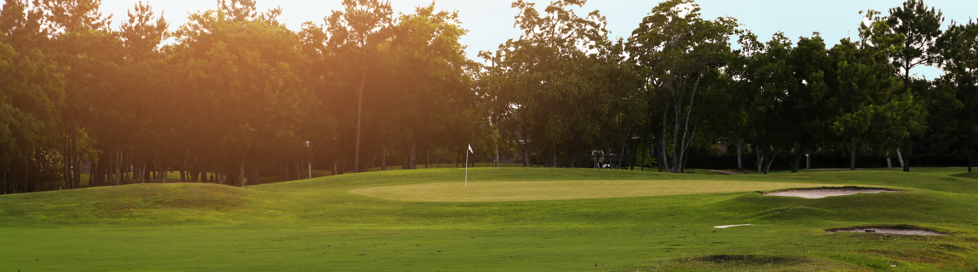 view of golf course green at sunset